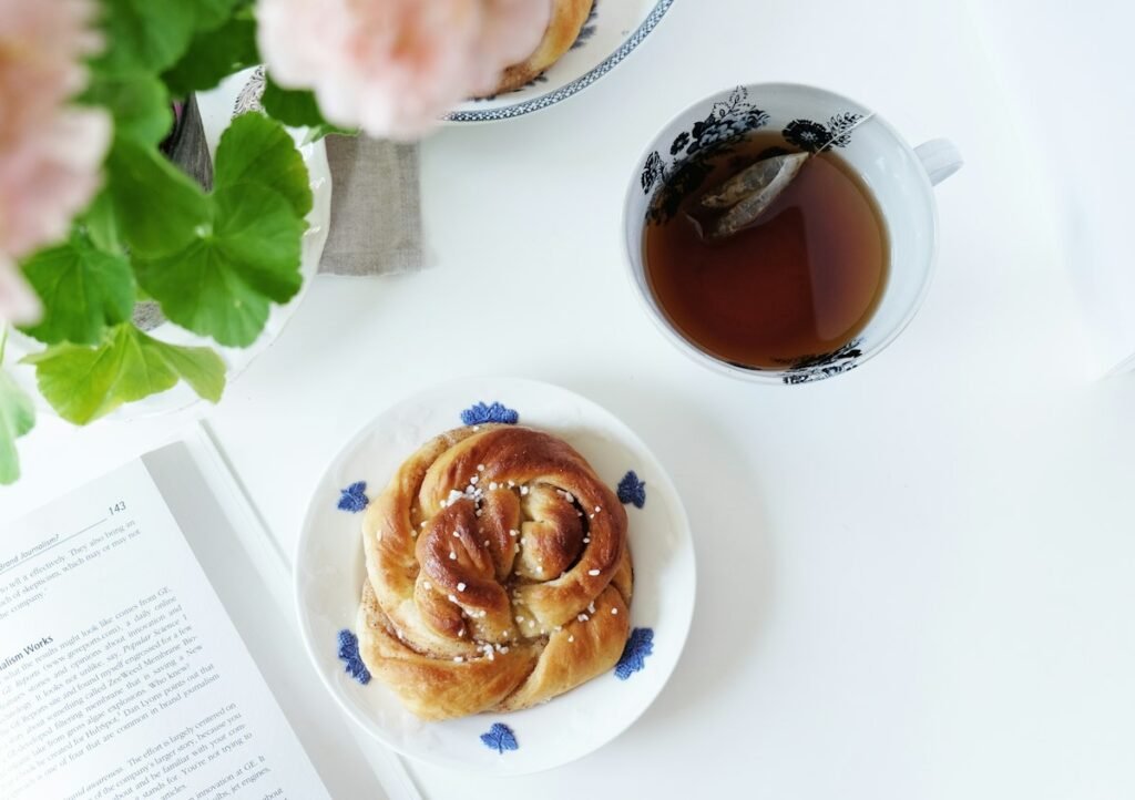 Coffee and a cinnamon bun on a white table