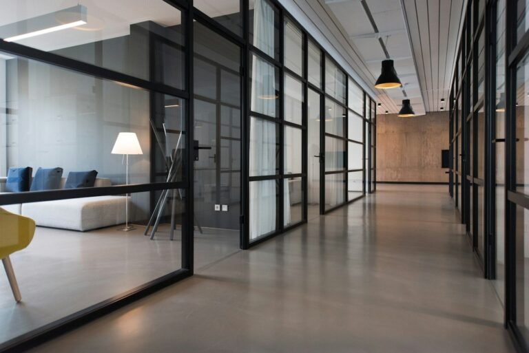 Bright modern office corridor with glass meeting rooms