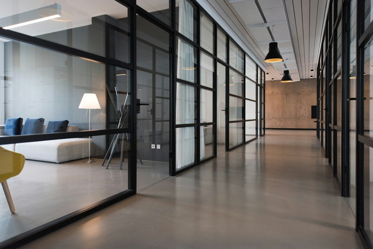 Bright modern office corridor with glass meeting rooms