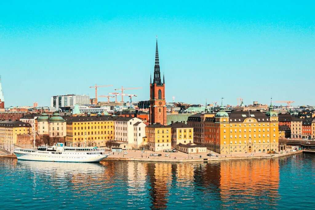 White boat on the water in front of Stockholm city buildings