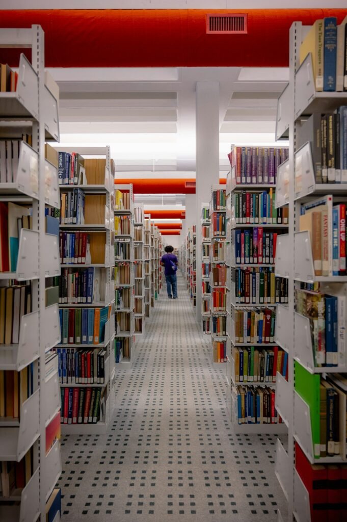 Student walking through a library filled with books